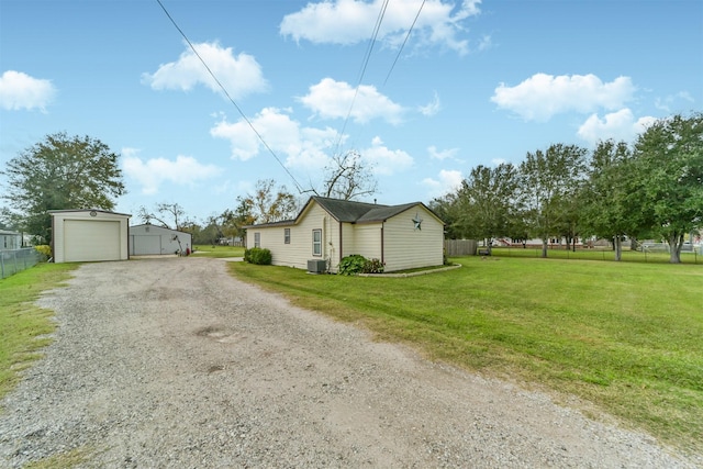 view of side of property featuring a yard and central AC