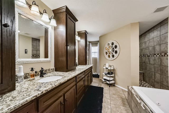 bathroom with tile patterned floors, vanity, and a relaxing tiled tub