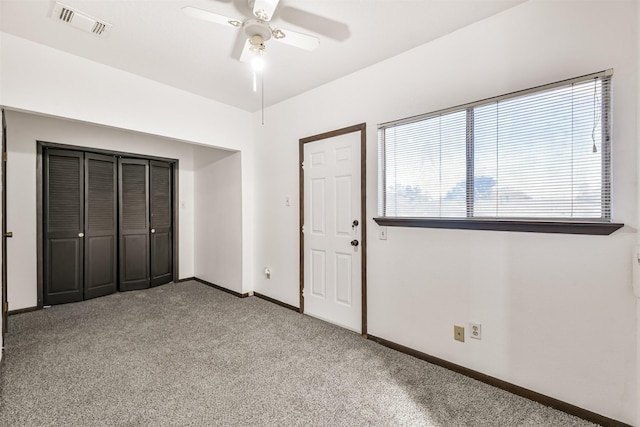 unfurnished bedroom with visible vents, baseboards, a ceiling fan, carpet, and a closet