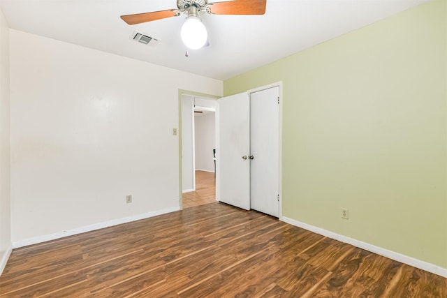 interior space with baseboards, visible vents, dark wood finished floors, and a ceiling fan