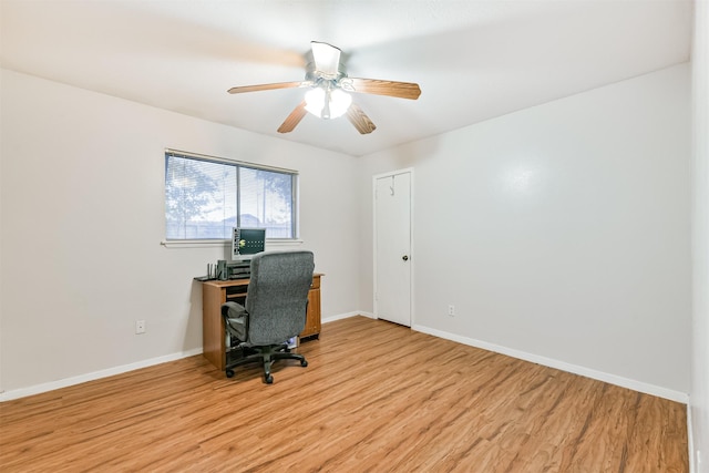 office space featuring light wood finished floors, ceiling fan, and baseboards