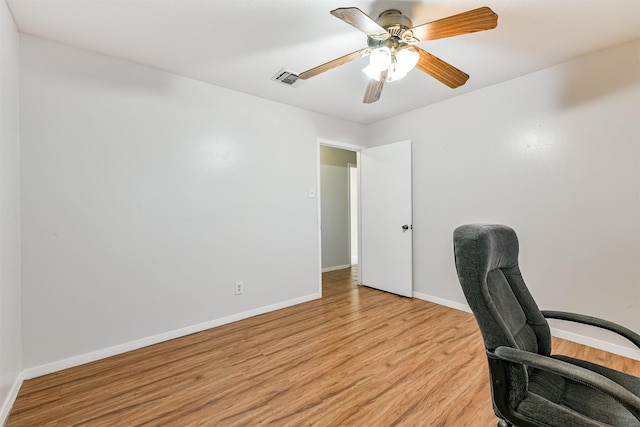 office featuring light wood-style flooring, visible vents, baseboards, and a ceiling fan