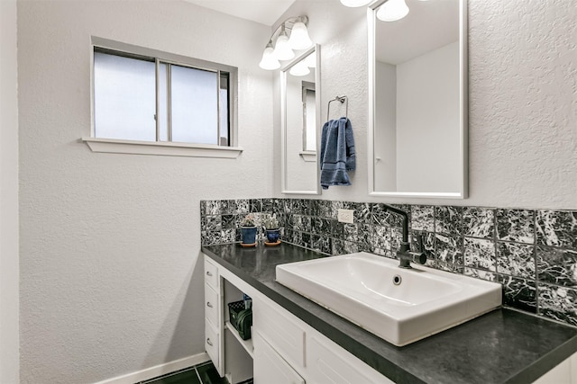 bathroom with tasteful backsplash, a textured wall, and vanity