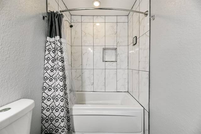 full bath featuring toilet, shower / bath combo, and a textured wall