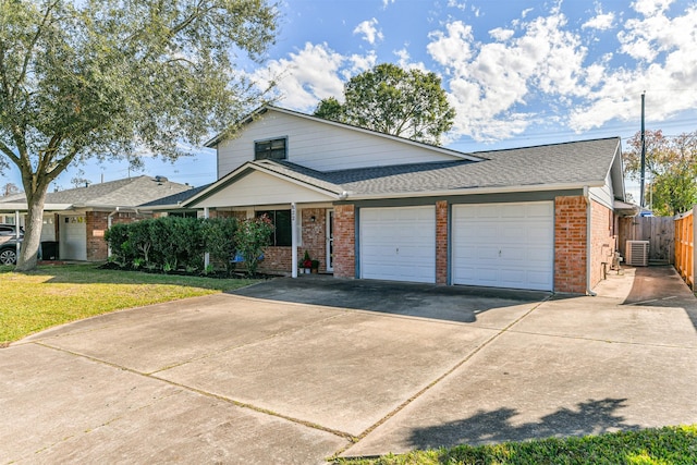 view of front facade with brick siding, central air condition unit, fence, a garage, and a front lawn