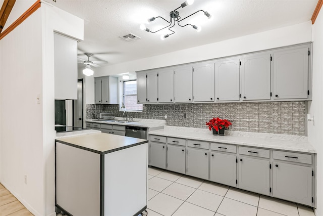 kitchen with light tile patterned floors, visible vents, a ceiling fan, light countertops, and backsplash