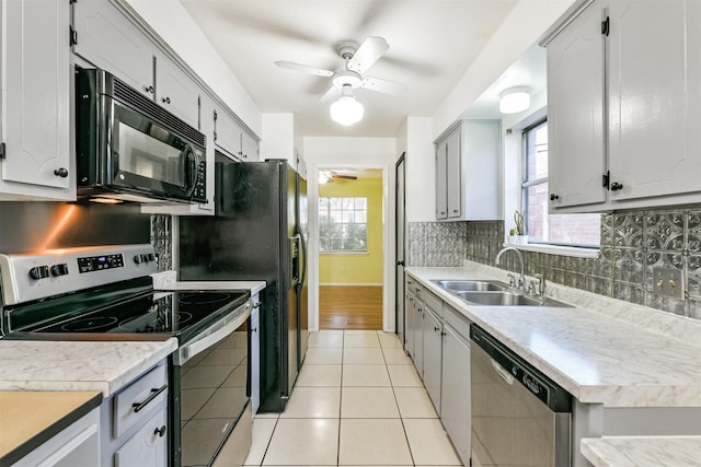 kitchen with appliances with stainless steel finishes, light countertops, a sink, and a ceiling fan