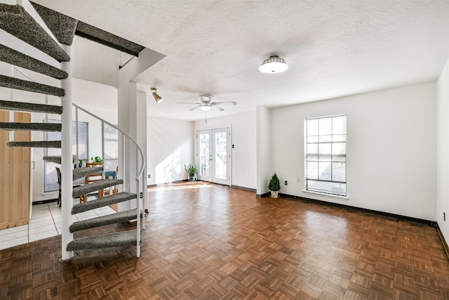 foyer with french doors, plenty of natural light, a textured ceiling, and stairs