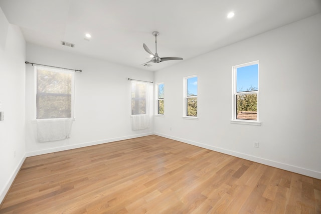 empty room featuring light hardwood / wood-style floors, a wealth of natural light, and ceiling fan