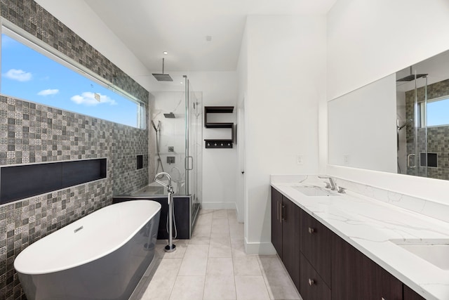 bathroom featuring a healthy amount of sunlight, vanity, and independent shower and bath