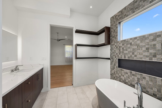 bathroom with a wealth of natural light, vanity, a bathing tub, and tile patterned floors