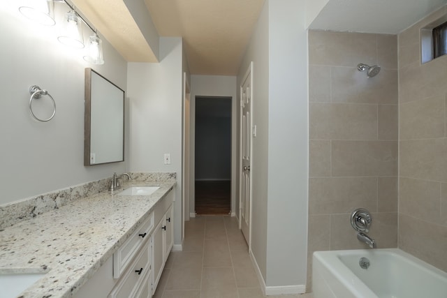 bathroom with tile patterned flooring, tiled shower / bath combo, and vanity