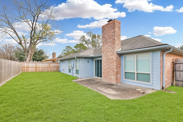 rear view of house with a patio area and a lawn