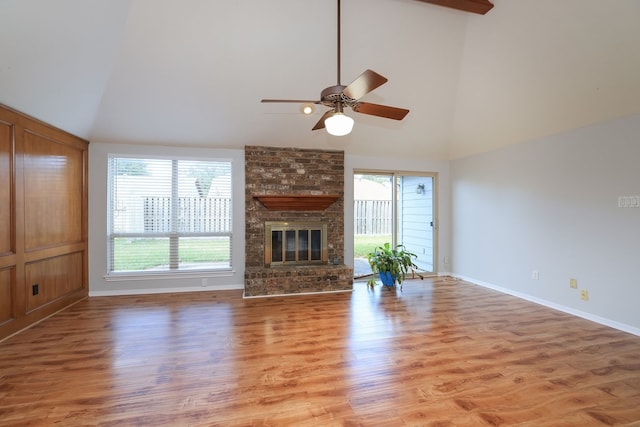 unfurnished living room with hardwood / wood-style flooring, high vaulted ceiling, ceiling fan, and a fireplace