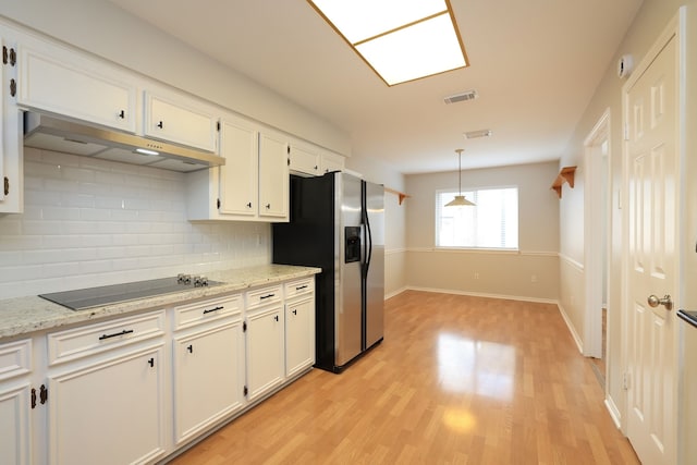 kitchen featuring stainless steel refrigerator with ice dispenser, black electric stovetop, white cabinetry, and backsplash