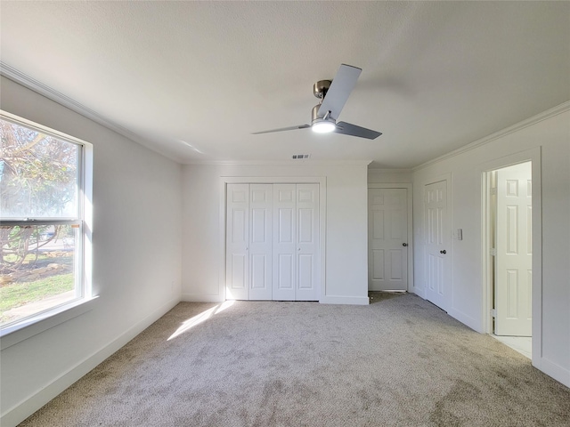 unfurnished bedroom with ceiling fan, light colored carpet, and ornamental molding