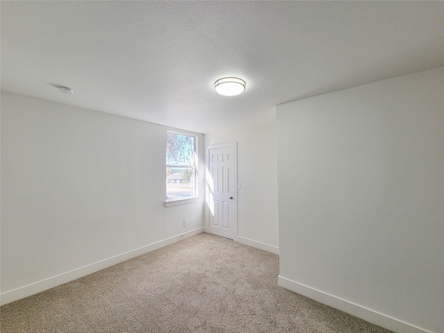 carpeted spare room featuring a textured ceiling