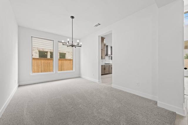 interior space featuring a notable chandelier and light carpet