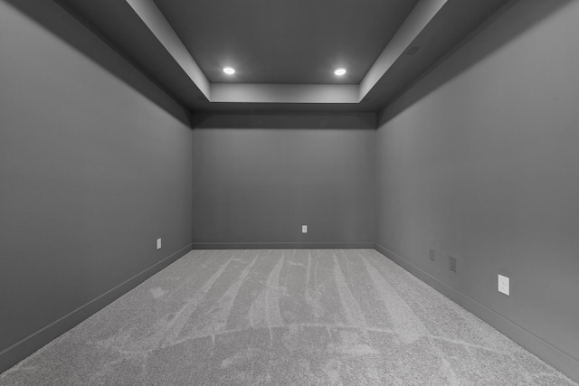 carpeted empty room featuring a tray ceiling