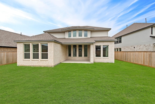 rear view of house featuring a lawn and a patio area