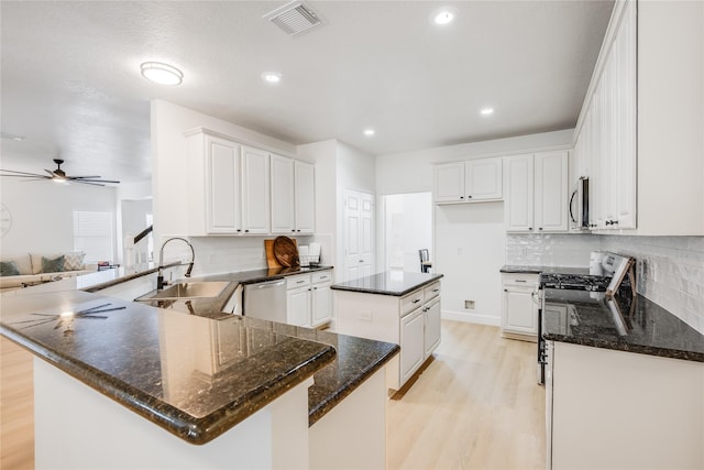 kitchen with white cabinetry, a kitchen island, light wood-type flooring, and appliances with stainless steel finishes