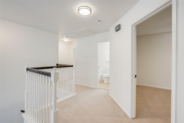 hallway featuring light colored carpet