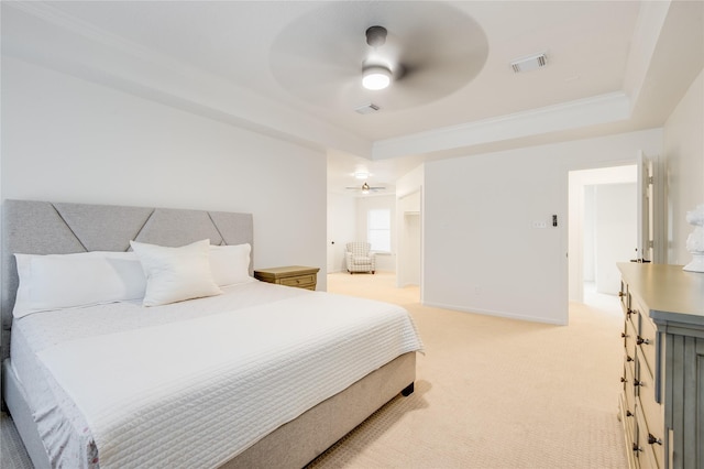 bedroom with a tray ceiling, light carpet, and ceiling fan