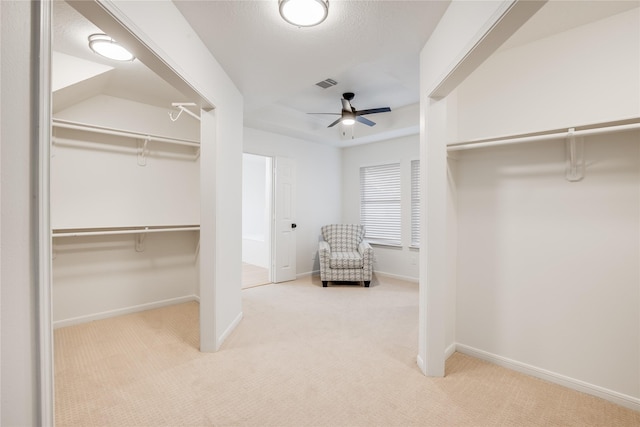 spacious closet featuring light carpet and ceiling fan