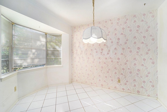 spare room with baseboards, a chandelier, tile patterned flooring, and wallpapered walls