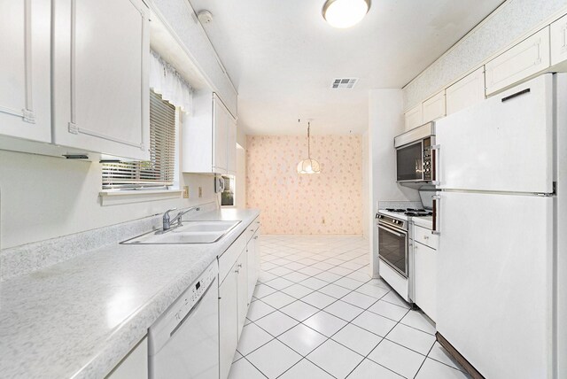 kitchen with pendant lighting, white appliances, white cabinets, sink, and light tile patterned flooring