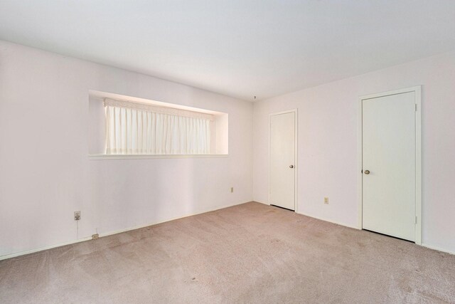 unfurnished room with light carpet