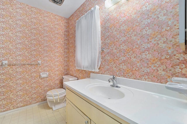 bathroom featuring vanity, visible vents, baseboards, wallpapered walls, and toilet