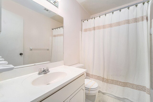 bathroom with a shower with shower curtain, vanity, and toilet