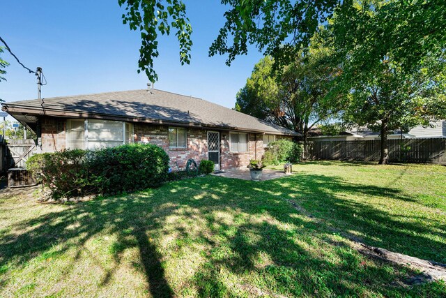 rear view of property with a yard and a patio