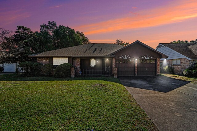 ranch-style house featuring a lawn and a garage