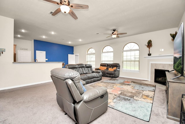 living room with light carpet, a fireplace, and ceiling fan