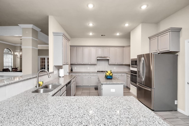 kitchen featuring gray cabinetry, light stone counters, sink, and appliances with stainless steel finishes