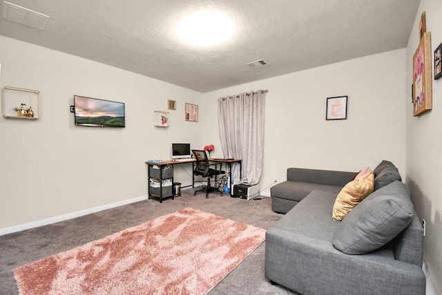 carpeted office space featuring a textured ceiling