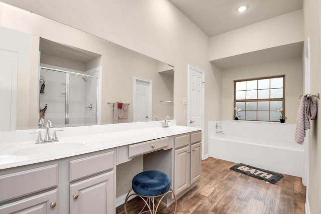 bathroom featuring hardwood / wood-style floors, vanity, and separate shower and tub