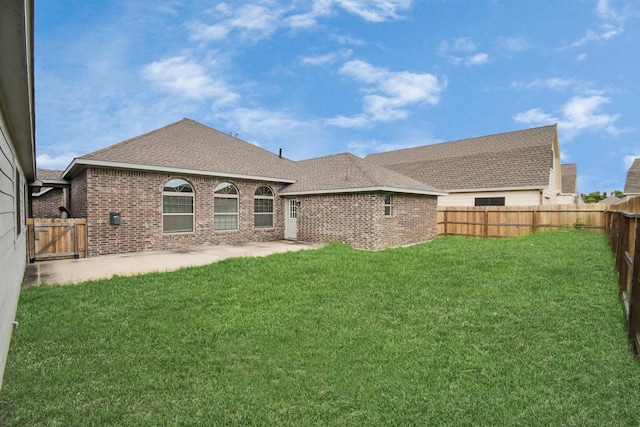 rear view of property with a lawn and a patio area