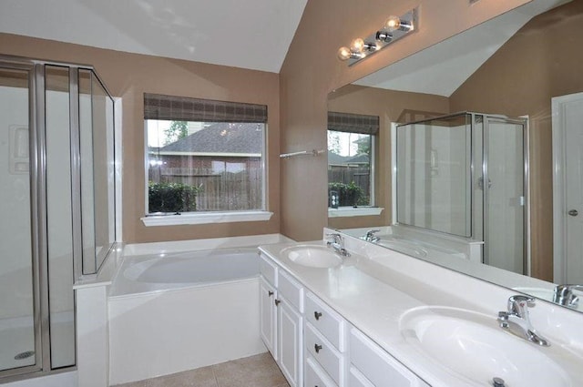 bathroom with tile patterned flooring, vanity, a healthy amount of sunlight, and vaulted ceiling