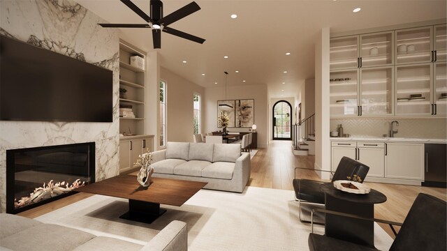 living room with ceiling fan, built in features, light hardwood / wood-style floors, and sink