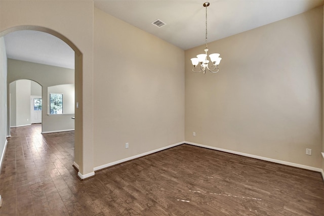 spare room with a chandelier, dark hardwood / wood-style flooring, and vaulted ceiling