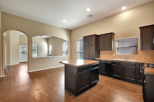 kitchen featuring tasteful backsplash, sink, black appliances, hardwood / wood-style flooring, and a center island