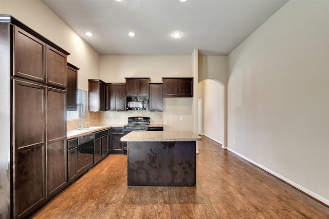 kitchen featuring a center island, sink, hardwood / wood-style floors, dark brown cabinets, and black appliances