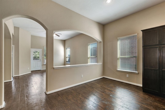 unfurnished room with ceiling fan and dark hardwood / wood-style flooring