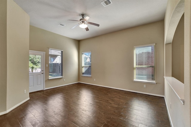 empty room featuring a textured ceiling, ceiling fan, and dark hardwood / wood-style floors