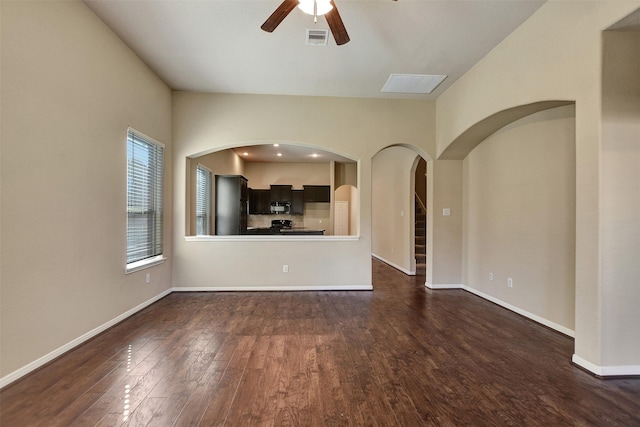 unfurnished living room featuring ceiling fan and dark hardwood / wood-style floors