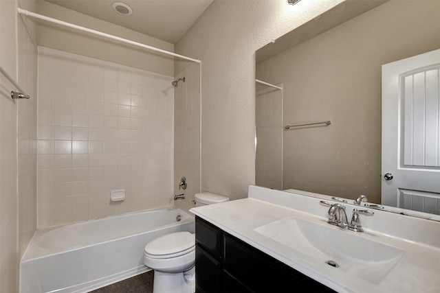 full bathroom featuring vanity, tiled shower / bath combo, and toilet