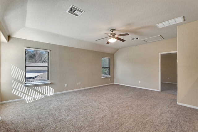 empty room featuring ceiling fan, carpet floors, a textured ceiling, and lofted ceiling